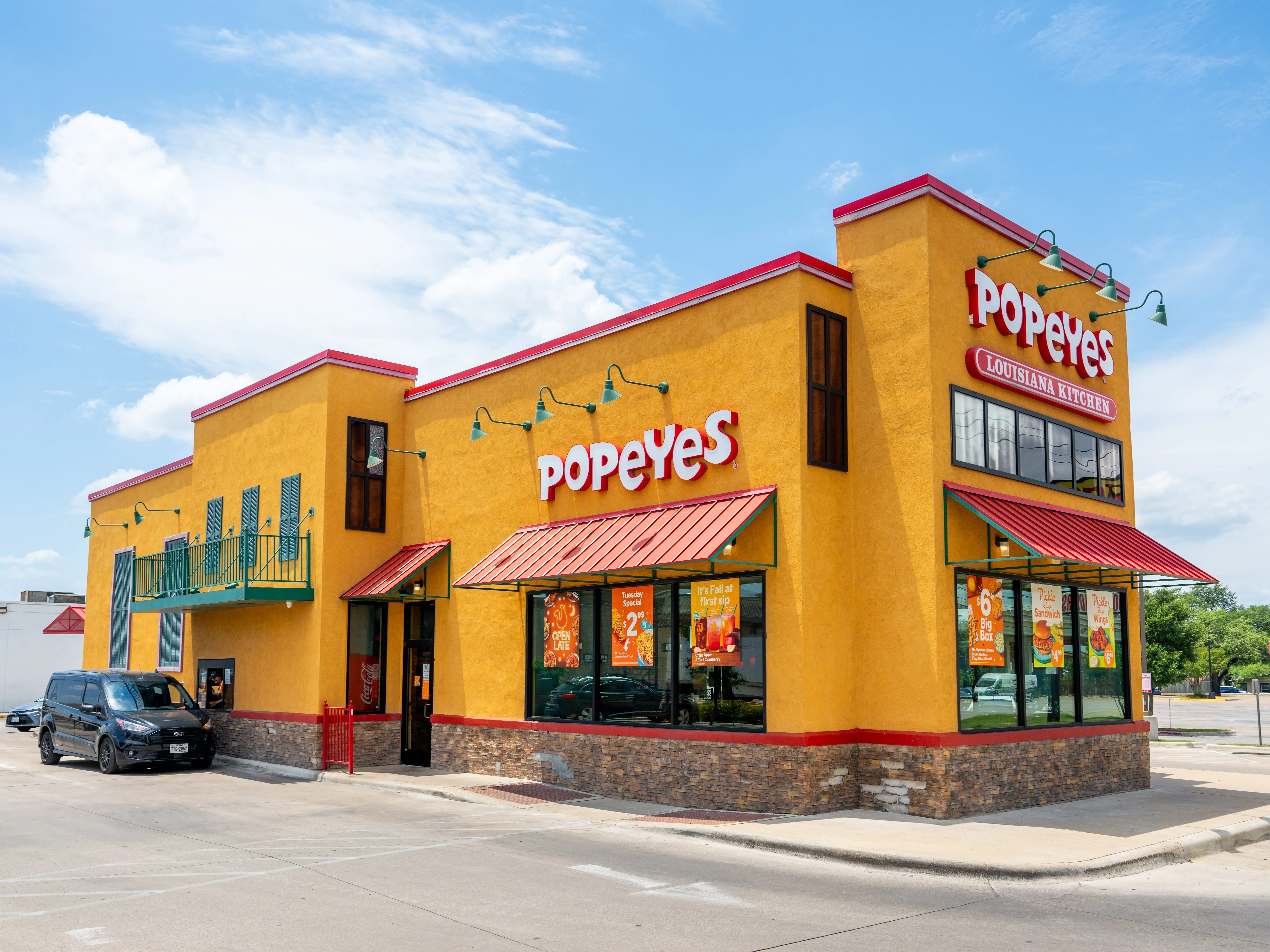 Popeyes restaurant with a car in the drive through in Austin, Texas.