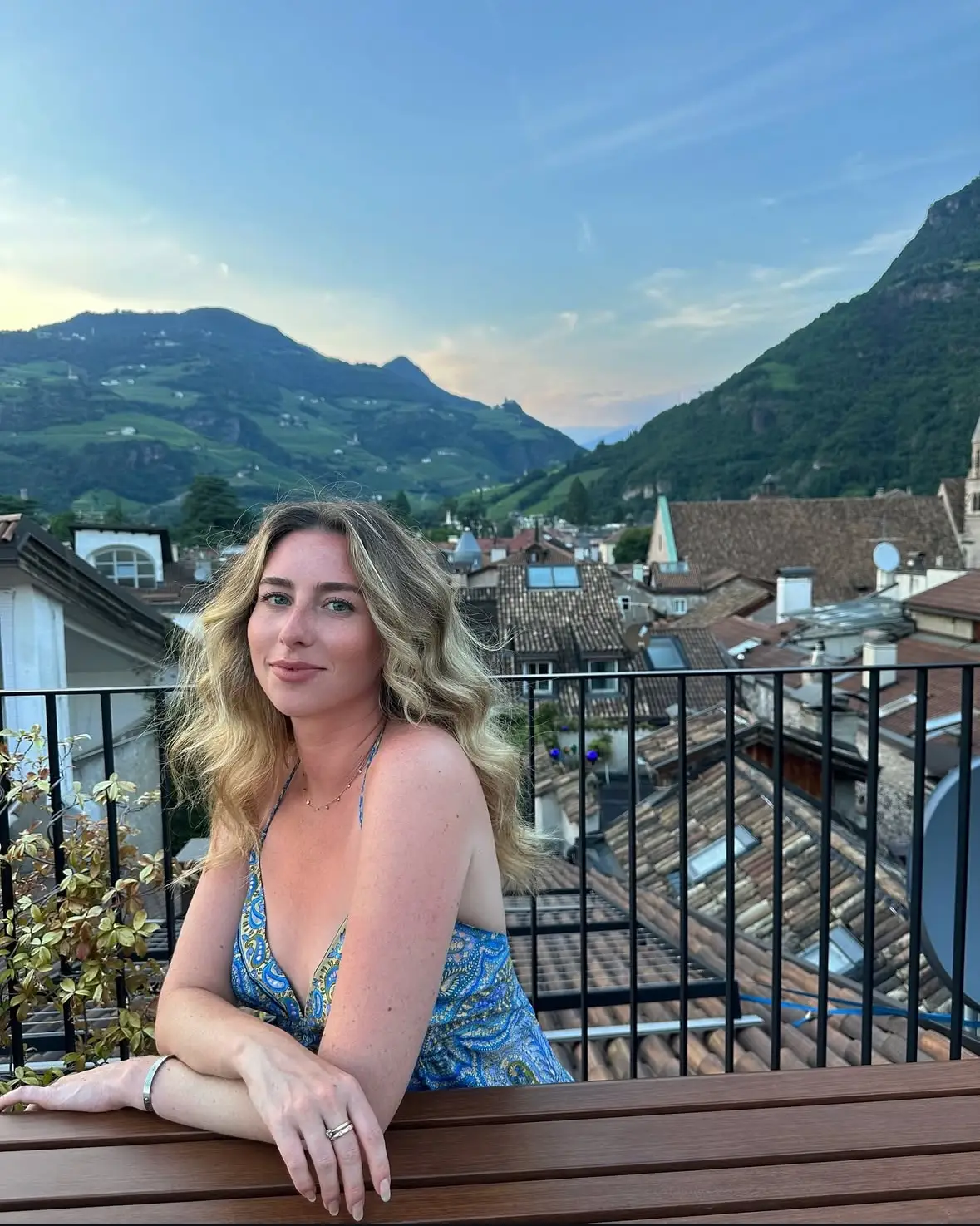 A woman posing with mountains in the background.