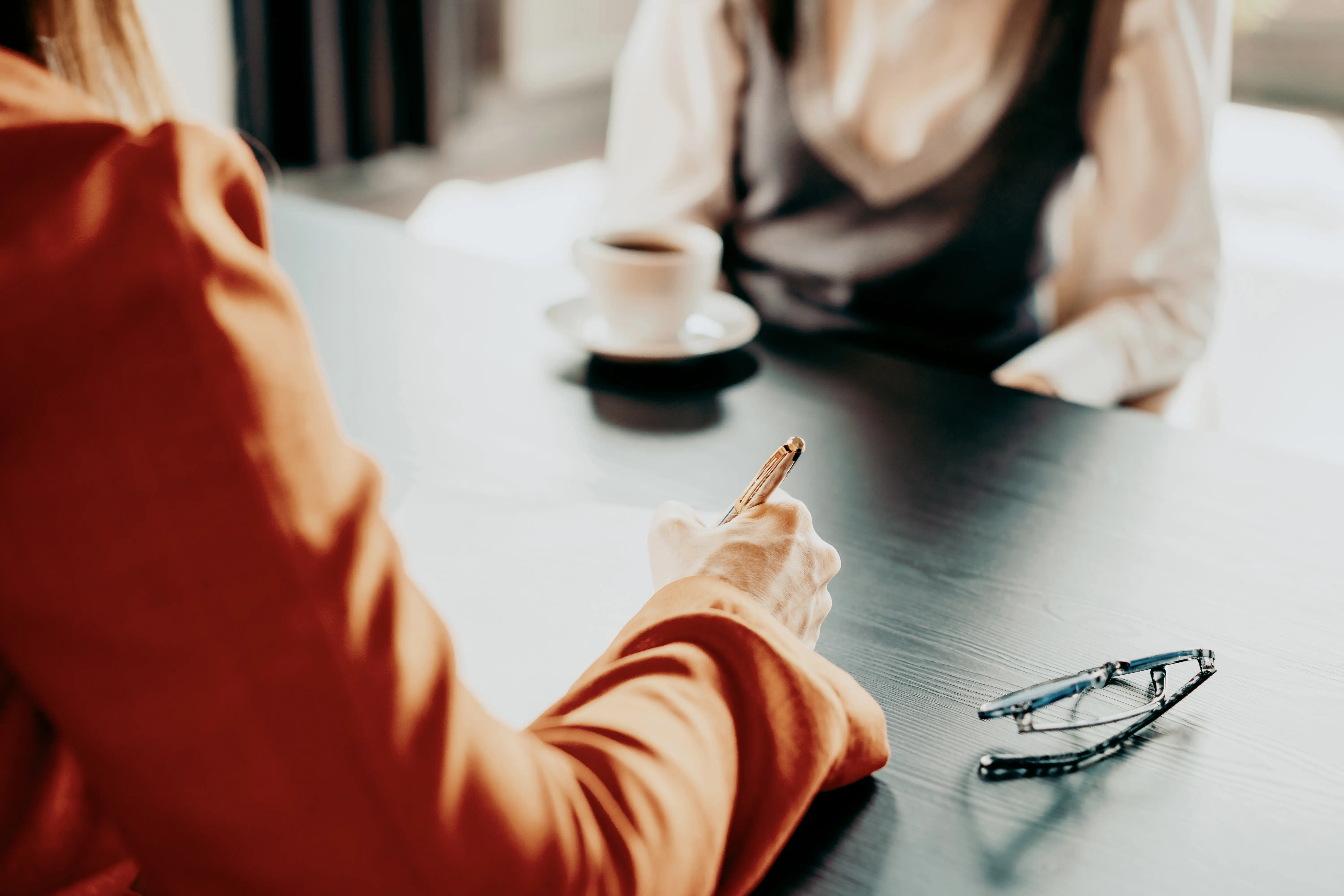 A close up of someone taking notes during an interview