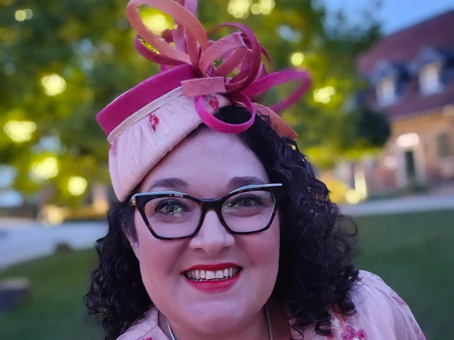 A woman wearing a pink dress and a matching hat