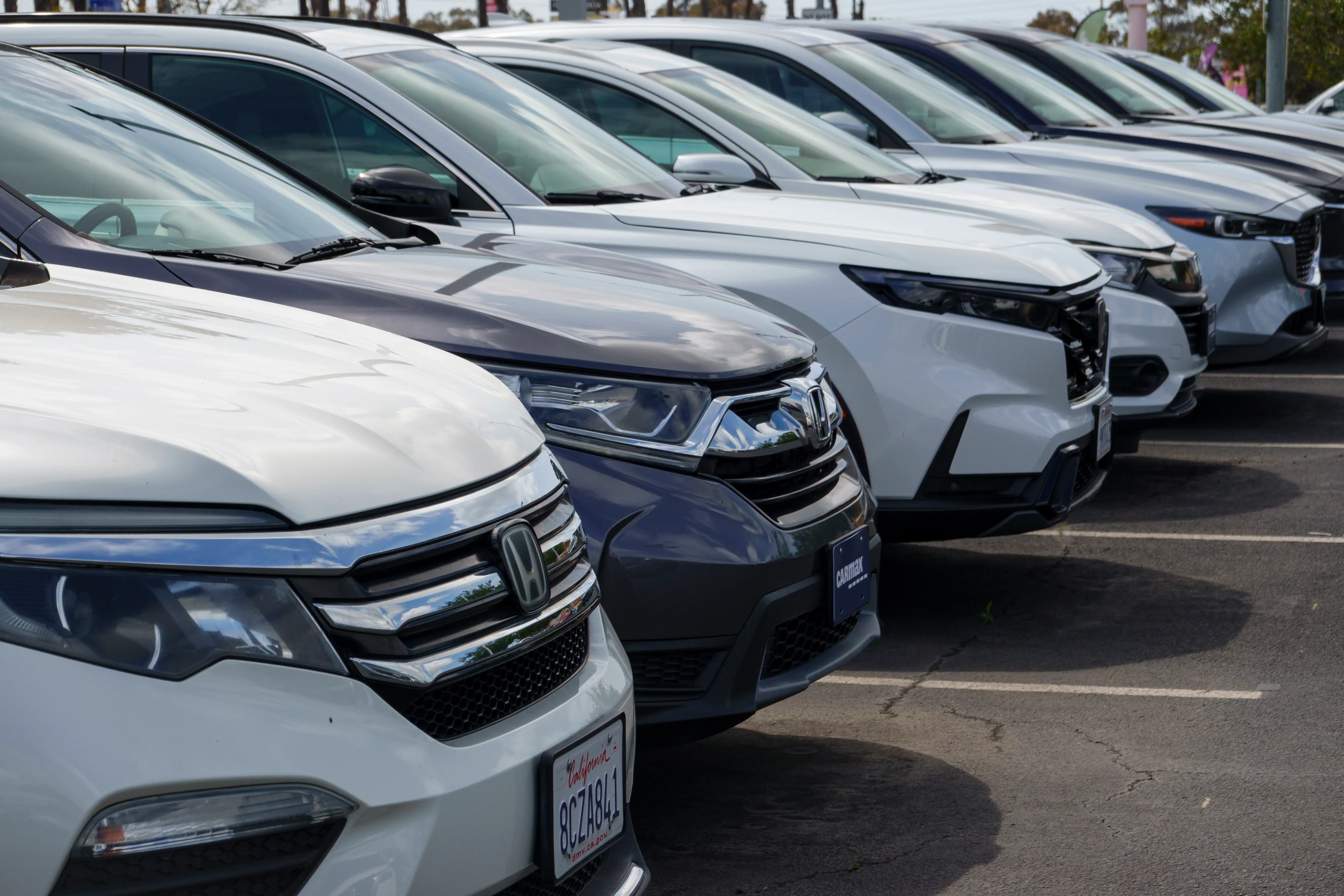 A lineup of cars in a parking lot.