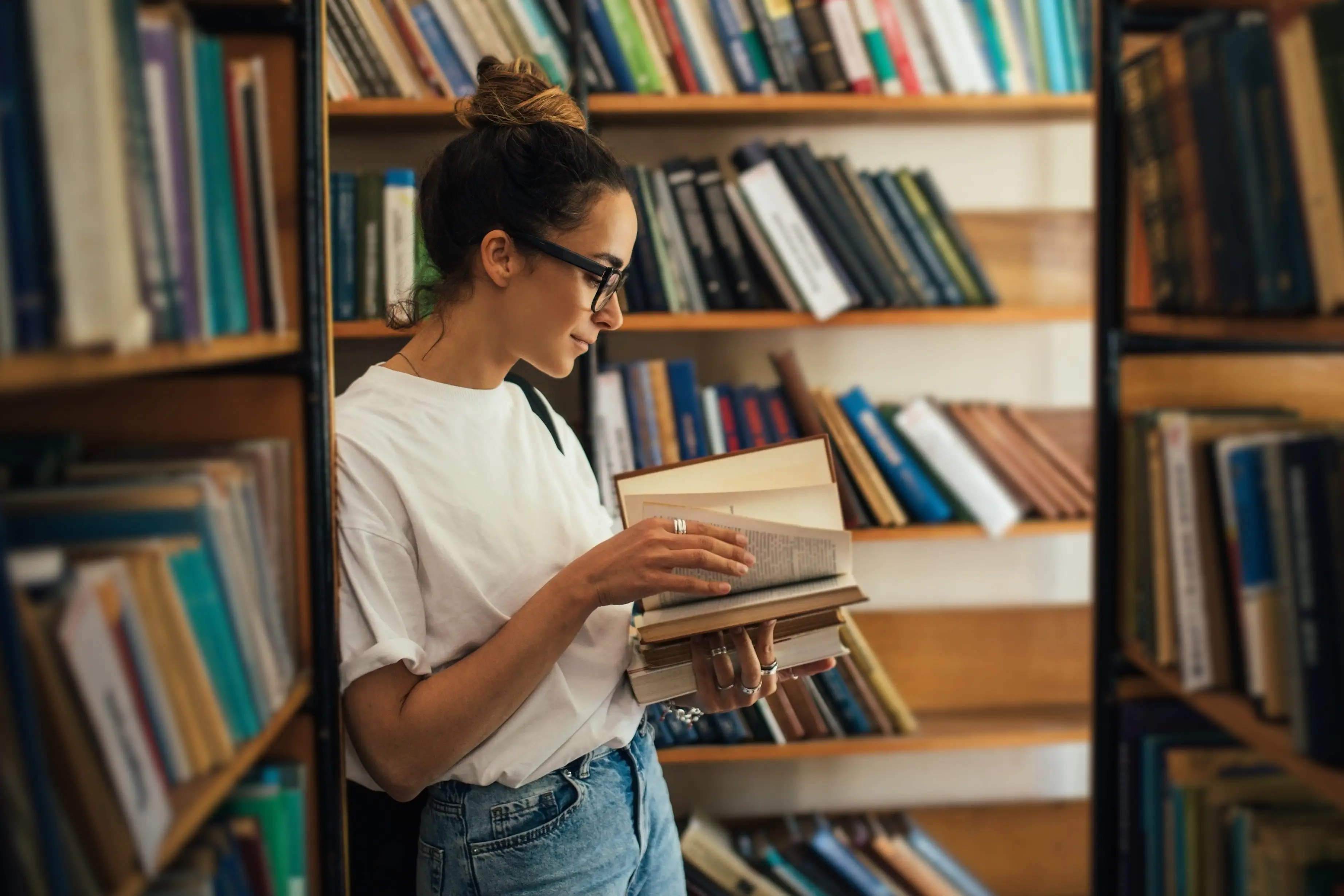 A woman reads a book in a bookstore.