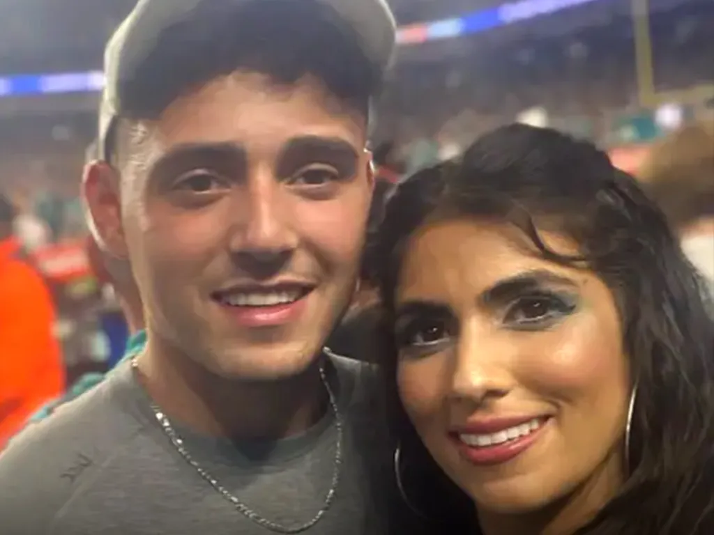 Caroline Schwitzky and a man in a gray hat smile for a close-up photo.