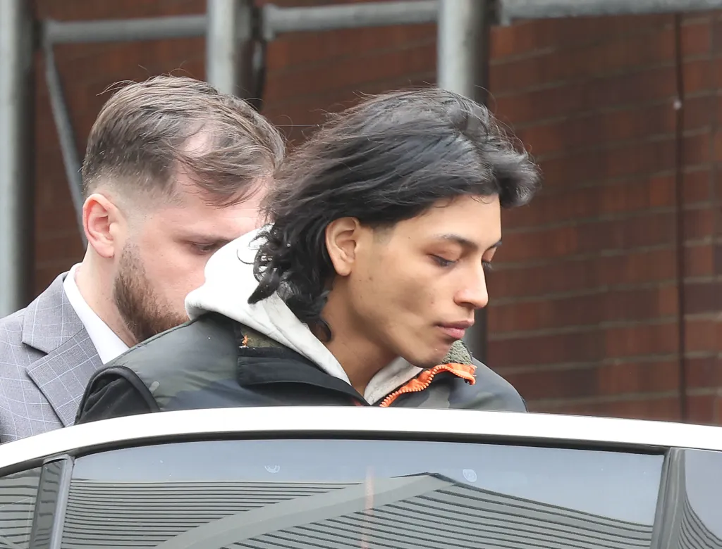 Luis Emmanuel Valencia Ponce being walked out of the 115th Police Precinct.