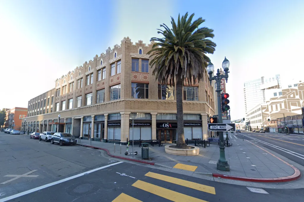 Oakland School for the Arts building with a palm tree in front, seen from the street.