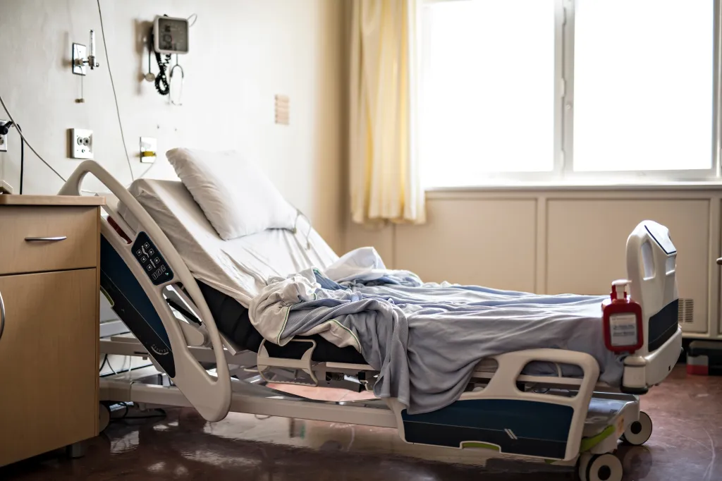 An empty hospital room with a bed and medical equipment.