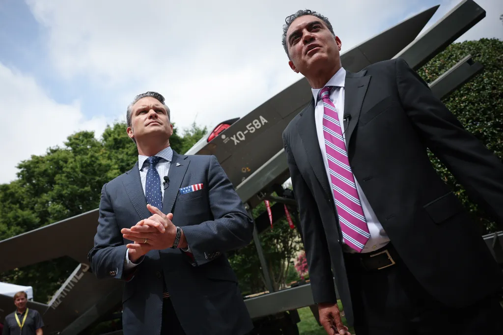 U.S. Secretary of Defense Pete Hegseth (L) is briefed on the XQ-58A Valkyrie UAS by Emil Michael 
