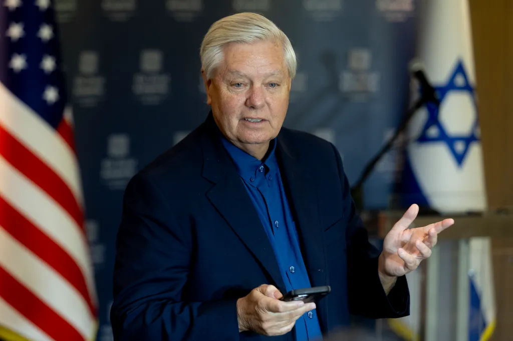 Lindsey Graham speaking with US and Israeli flags in the background.