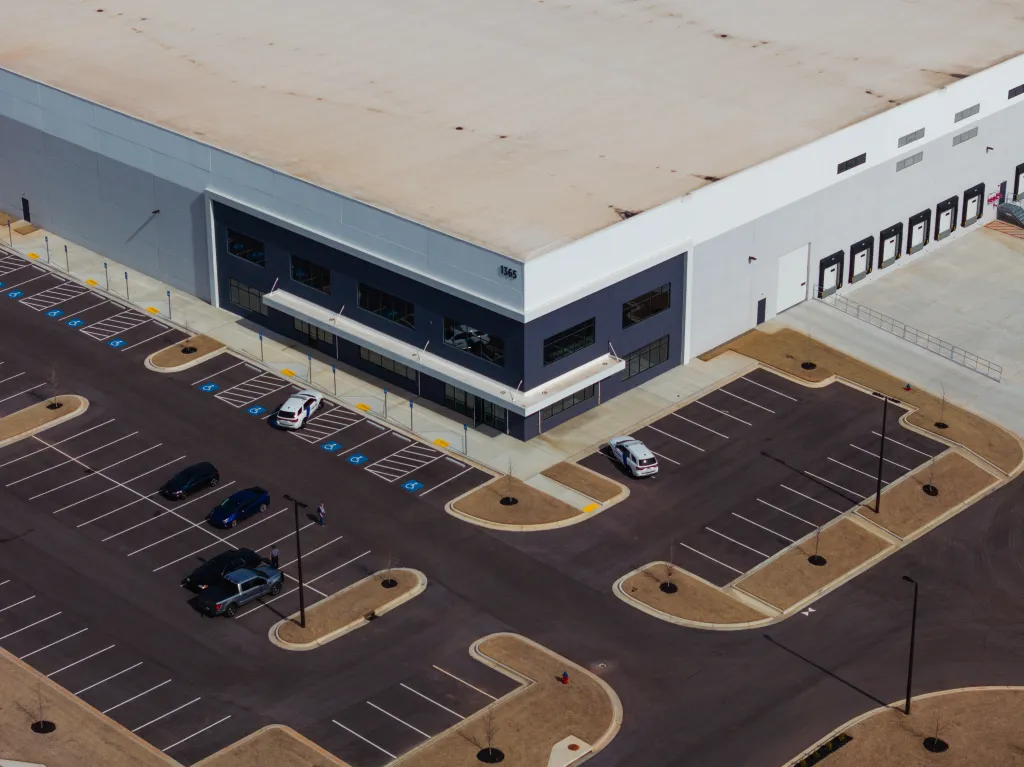 Aerial view of a large commercial building with a spacious parking lot.