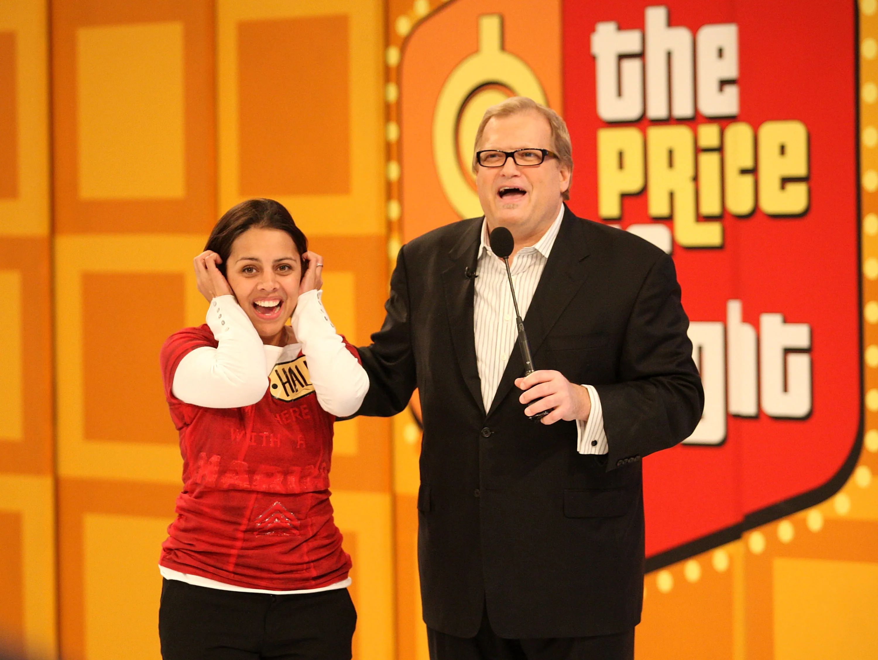 Drew Carey and a contestant on the set of The Price is Right.