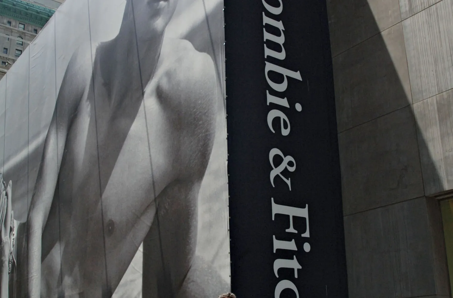 A streetcorner billboard shows a black-and-white photo of a shirtless man.