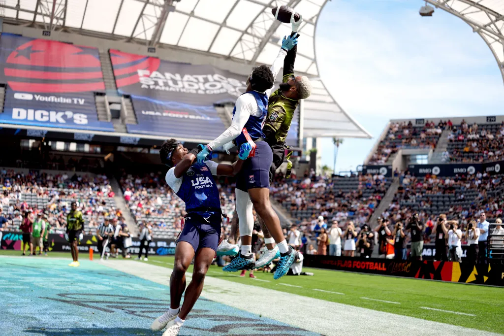 Two flag football players jump to catch a football during the Fanatics Flag Football Classic.