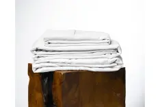 A set of white sheets on a log.