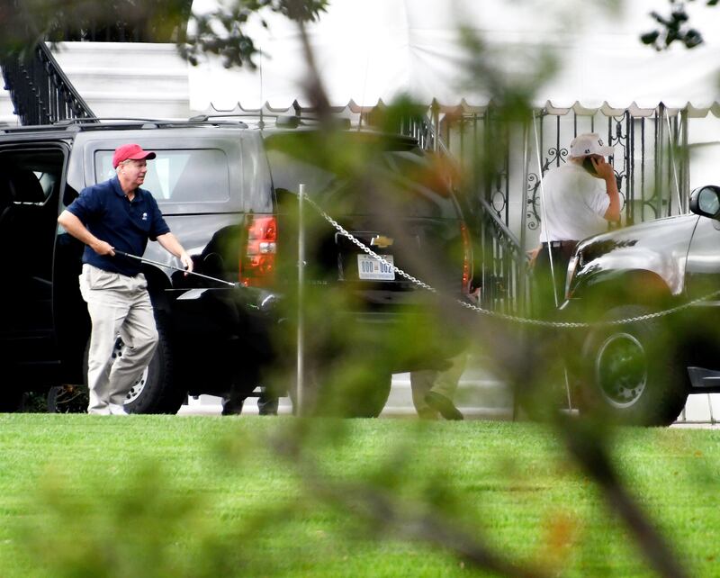 WASHINGTON, DC - OCTOBER 14: (AFP OUT) Senator Lindsey Graham (R-SC), left, carries one of his golf clubs as he leaves the presidential limo at the White House on October 14, 2017 in Washington, DC. U.S. President Donald Trump is seen at right talking on the phone. The two are returning after playing a round of golf. (Photo by Ron Sachs - Pool/Getty Images)