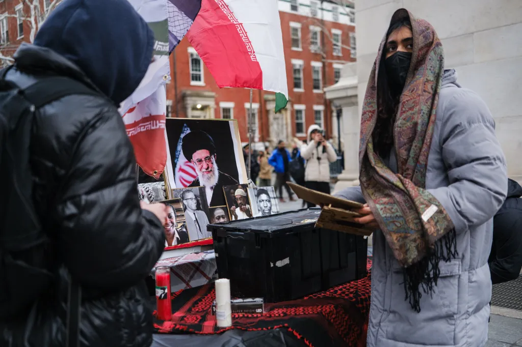 People attending a vigil with photos of Ayatollah Ali Khamenei and other prominent figures.