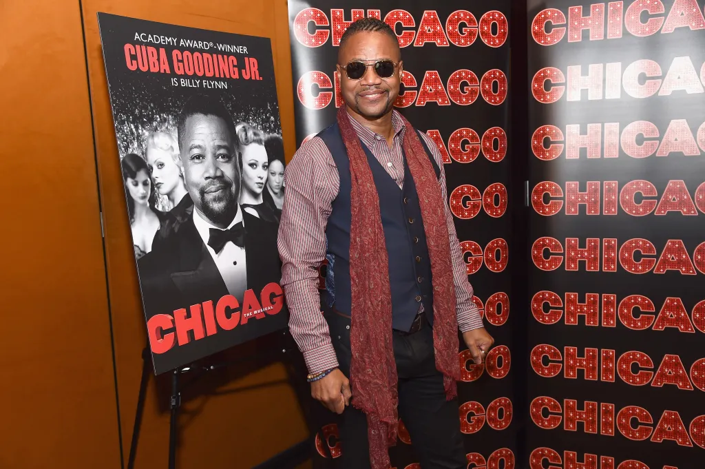 Cuba Gooding Jr. standing next to a poster for