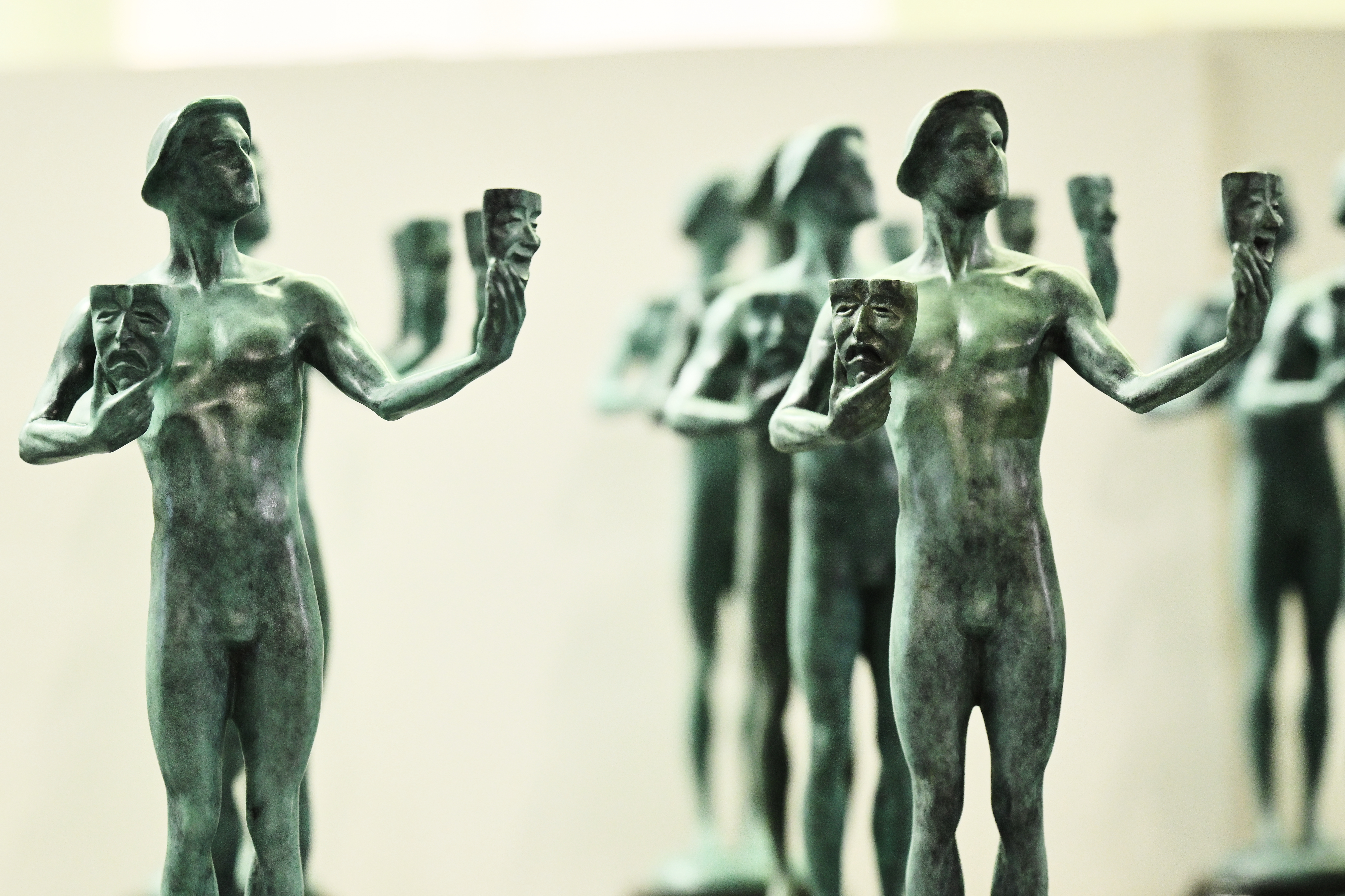 Actor statuettes with a comedy and tragedy mask.