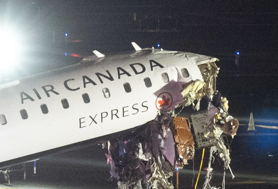 Air Canada Express airplane with a severely damaged nose at night.