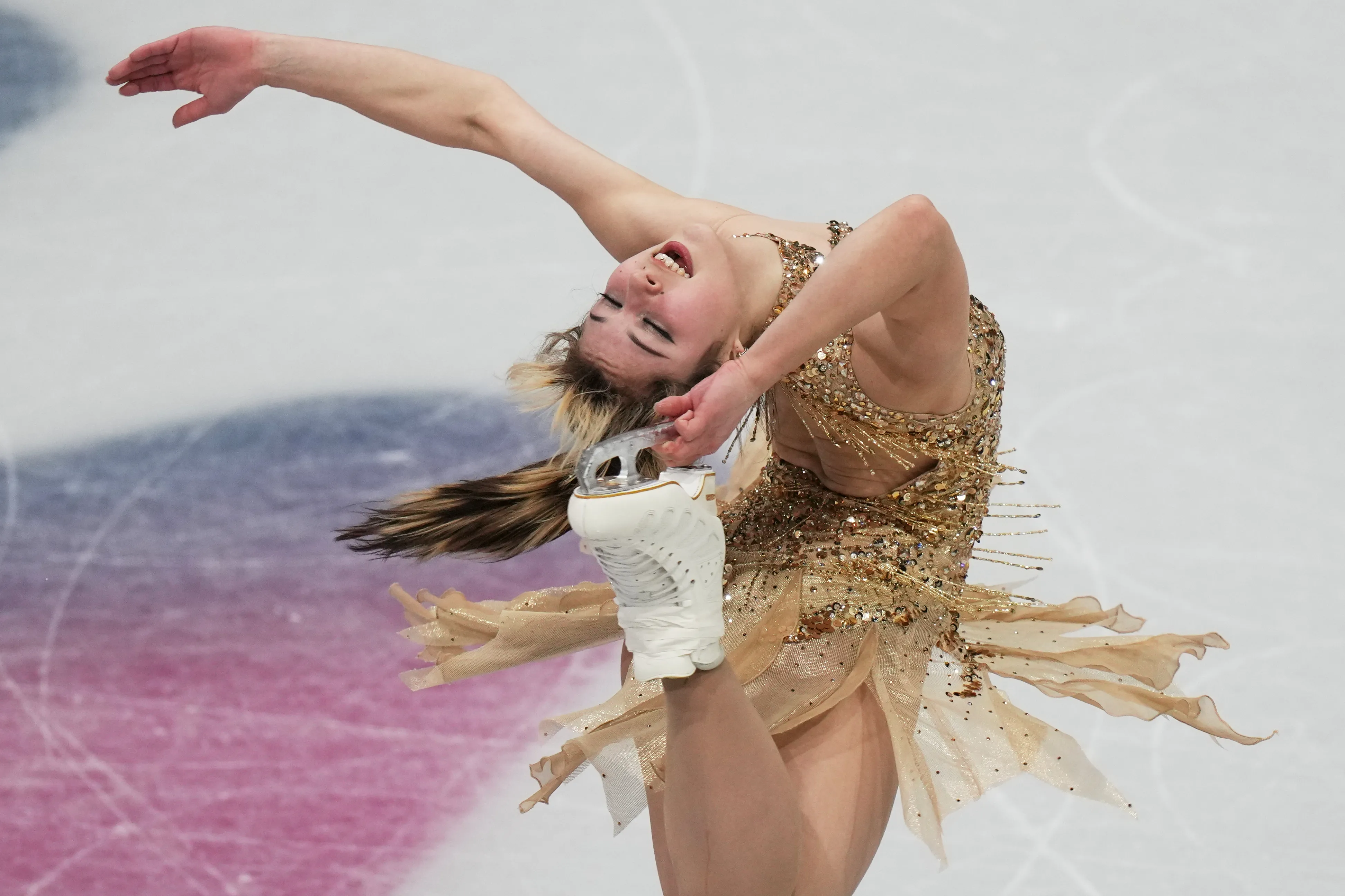 Alysa Liu performing a figure skating move at the Winter Olympics.