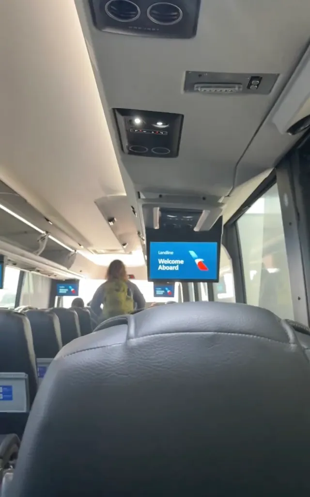 A person sitting on a bus that reads 
