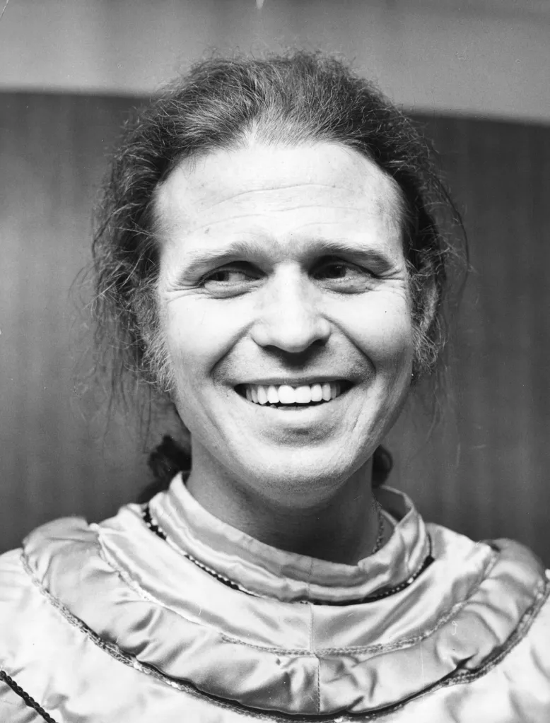 Black and white portrait of American recording artist Country Joe McDonald smiling.