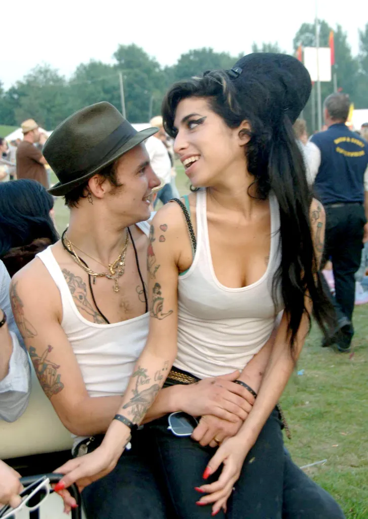 Amy Winehouse and Blake Fielder-Civil sitting closely together, smiling at each other.