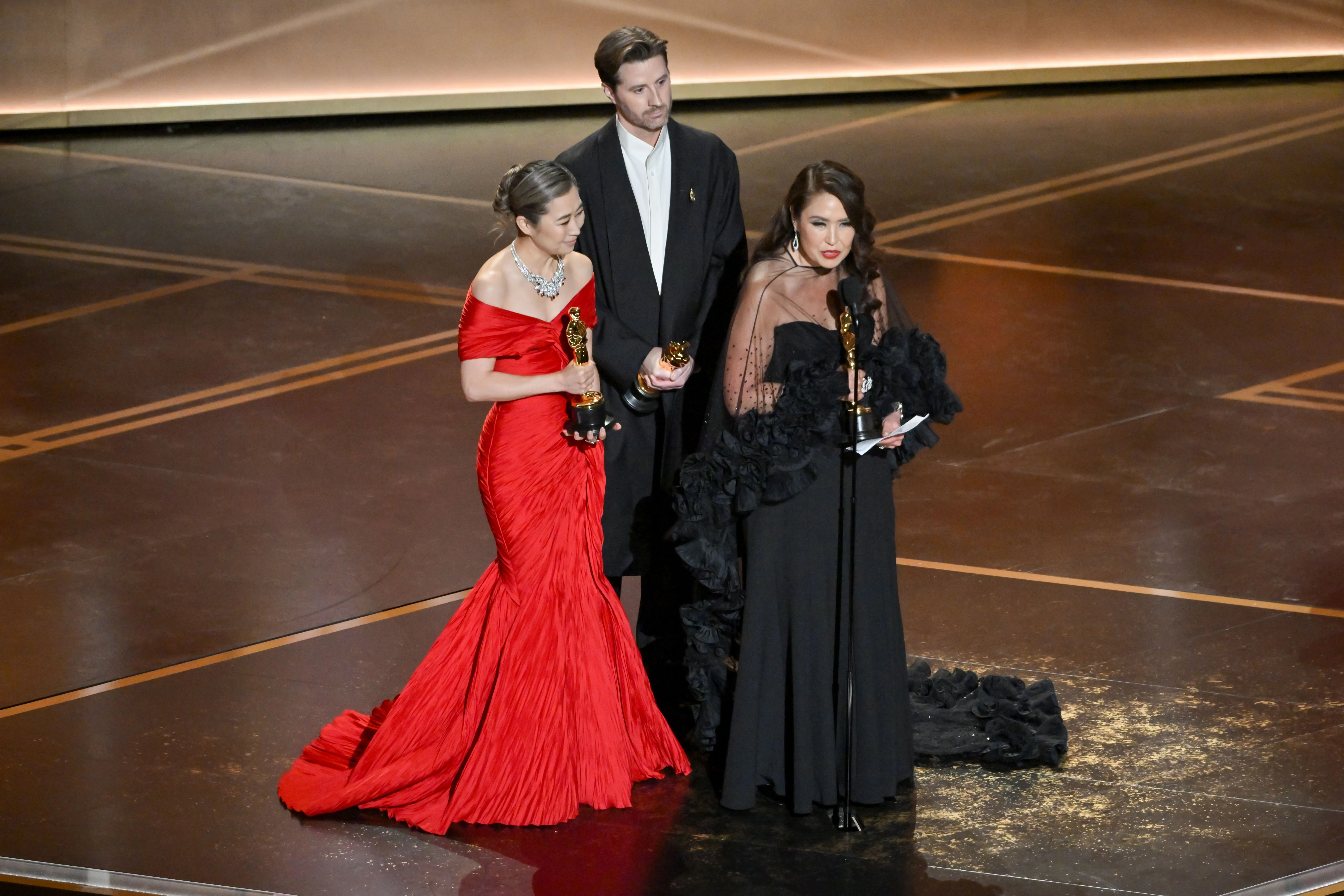 Maggie Kang (in red), Chris Appelhans and Michelle Wong accepting the award for Best Animated Feature at the 98th Annual Academy Awards