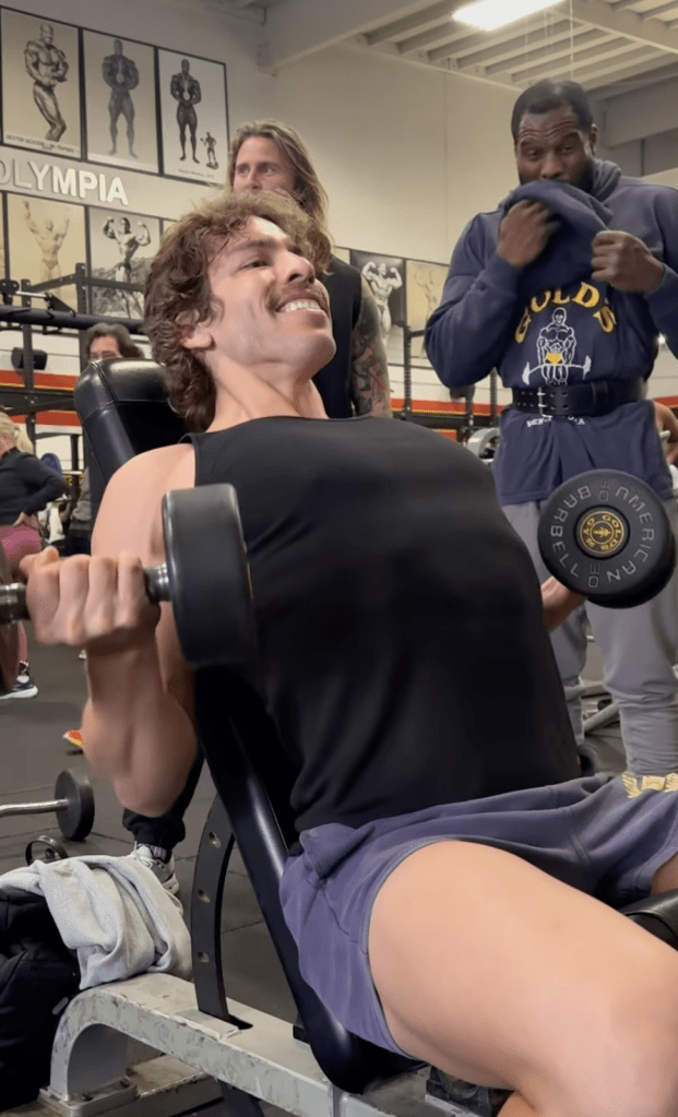 Joseph Baena lifting weights at Gold's Gym while being trained by his father, Arnold Schwarzenegger.