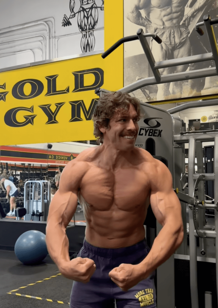 Joseph Baena flexing in a gym, with the Gold's Gym logo visible in the background.
