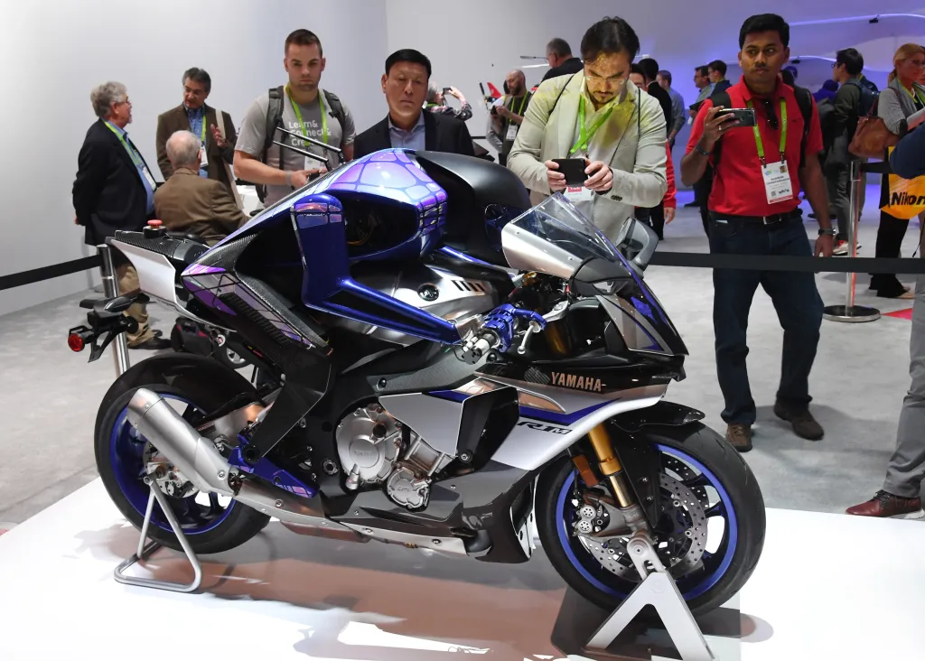 Attendees looking at the Yamaha Motobot autonomous motorcycle-riding humanoid robot.