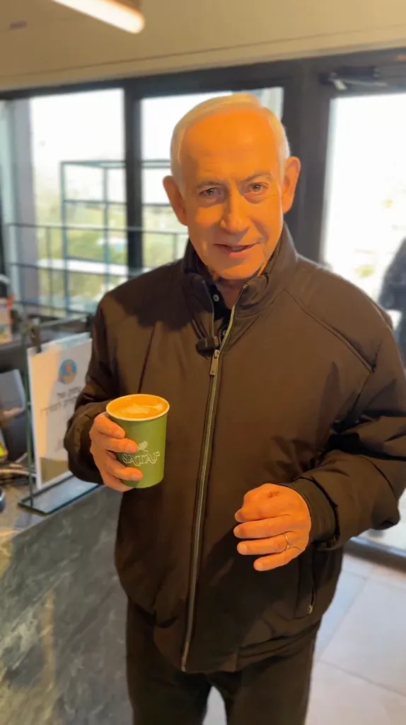 Benjamin Netanyahu holding a coffee cup.