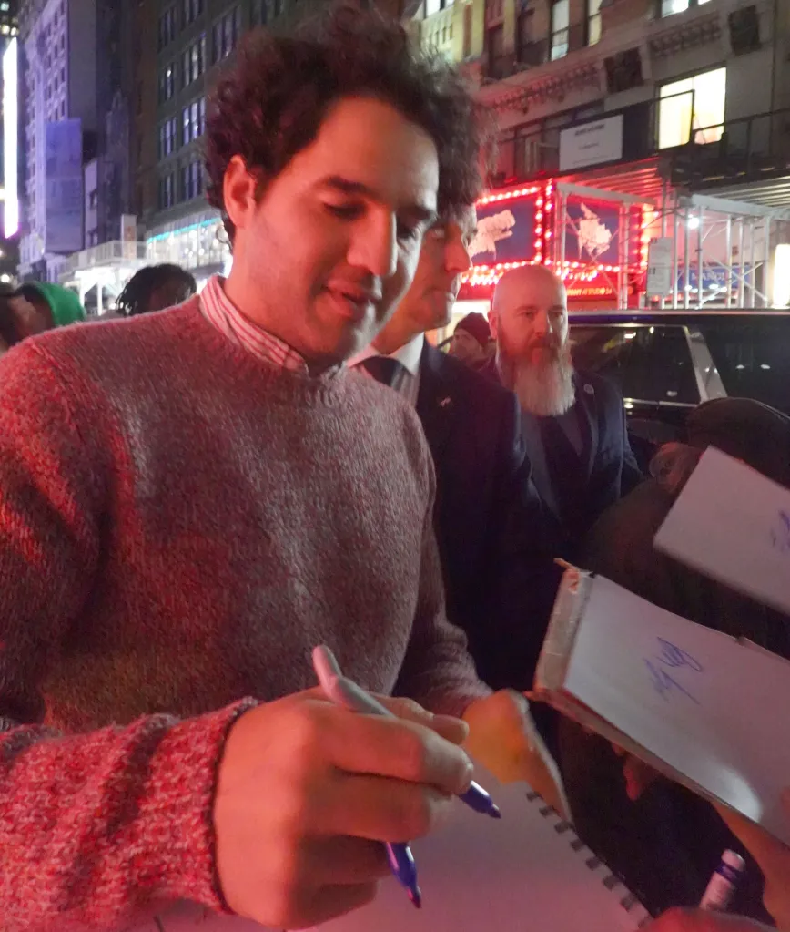 Benny Safdie signing autographs for fans in Midtown Manhattan.