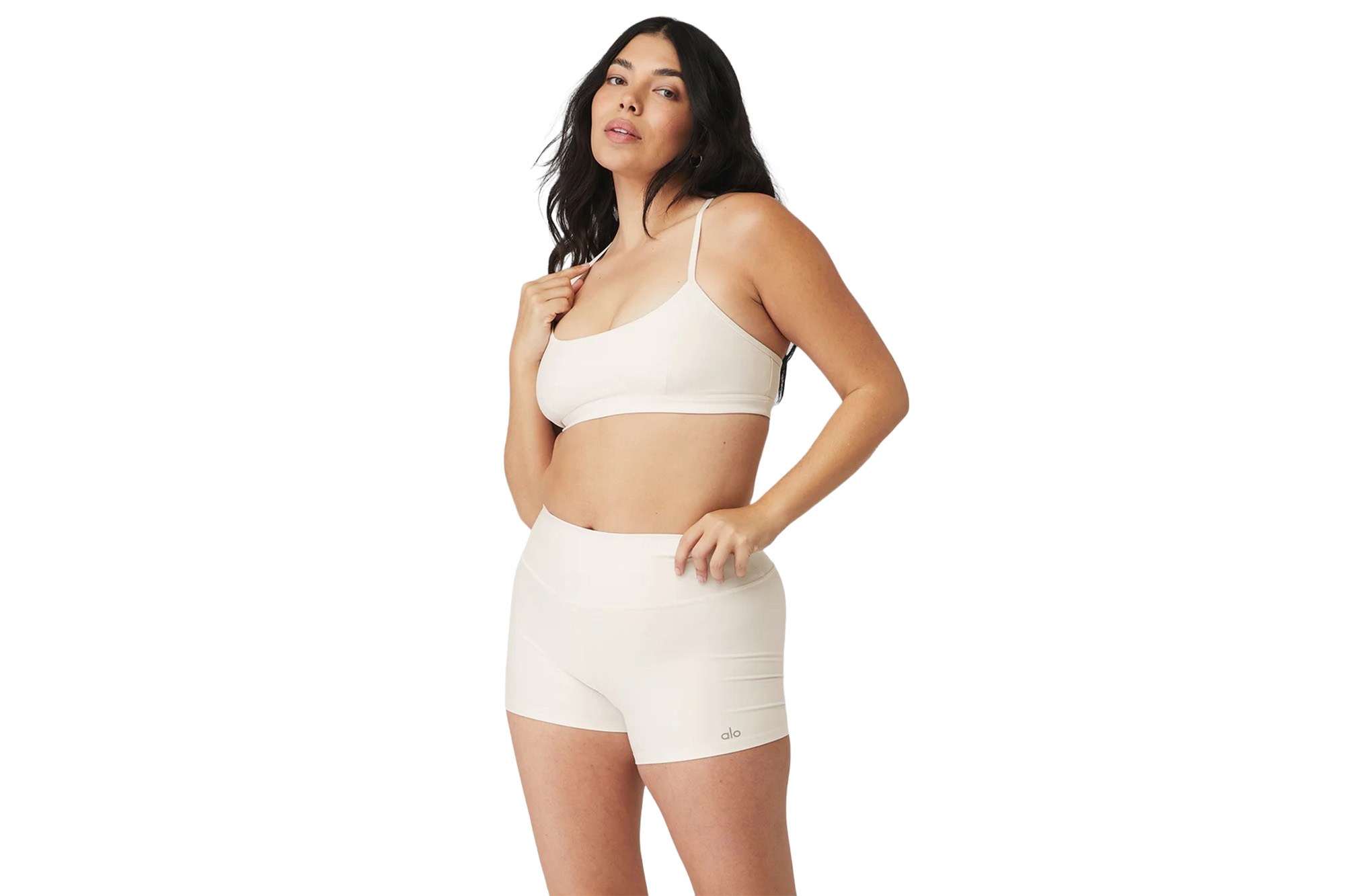 A model in a white bra and spandex shorts