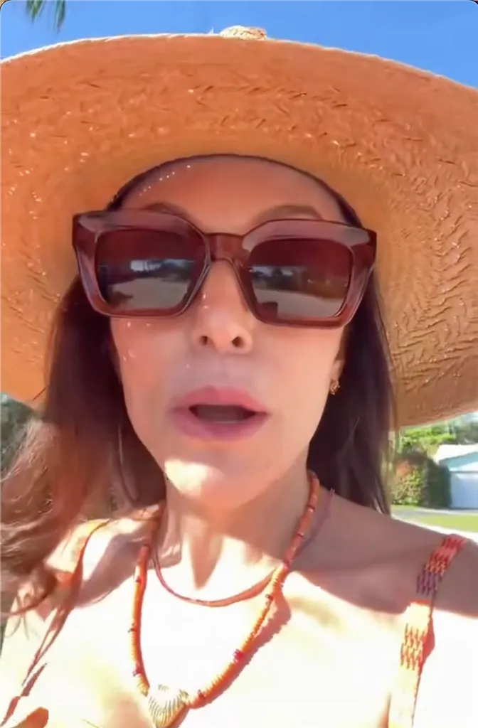Bethenny Frankel wearing a straw hat and sunglasses.
