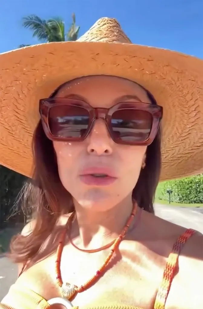Bethenny Frankel wearing sunglasses and a straw hat.