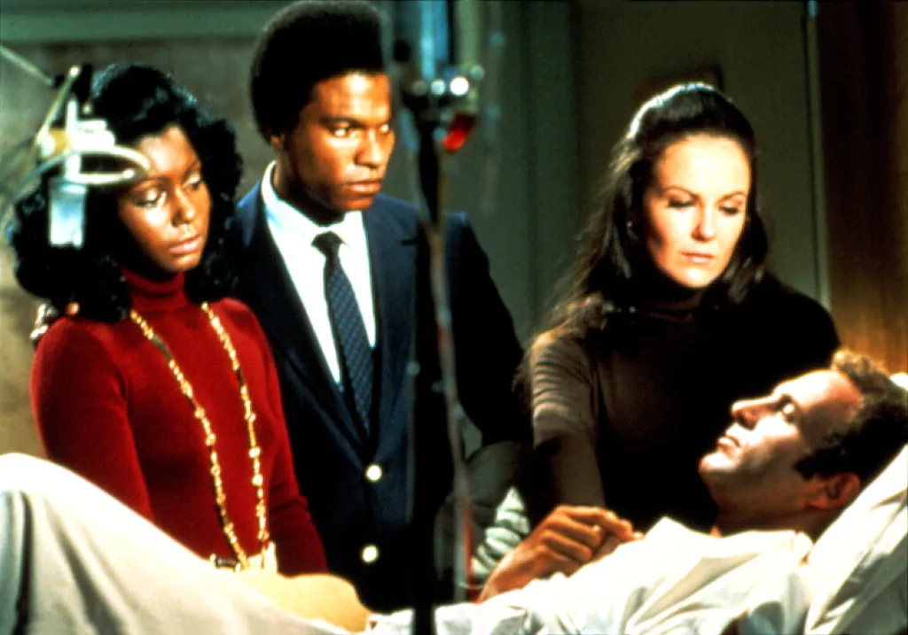 Still from the 1971 TV movie *Brian's Song* with Judy Pace as Linda Sayers, Billy Dee Williams as Gale Sayers, Shelley Fabares as Joy Piccolo, and James Caan as Brian Piccolo.