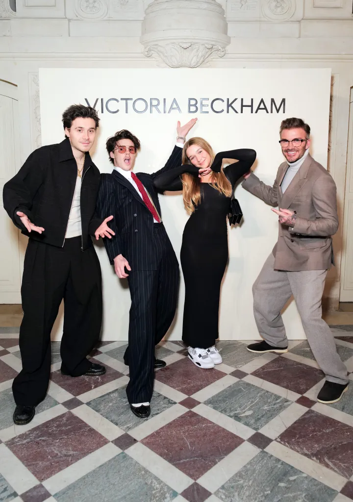 Brooklyn Beckham, Cruz Beckham, Harper Beckham, and David Beckham pose at the Victoria Beckham AW24 show in Paris.