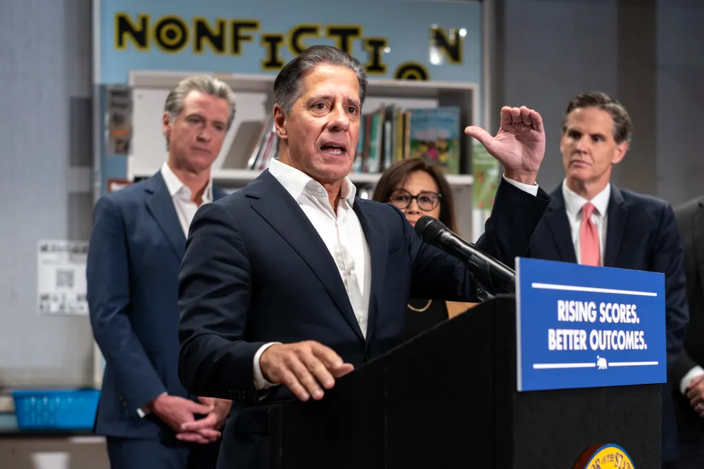 LAUSD Superintendent Alberto Carvalho speaks at a podium with California Governor Gavin Newsom, Martha Hernandez of California Together, and Marshall Tuck of EdVoice in the background.