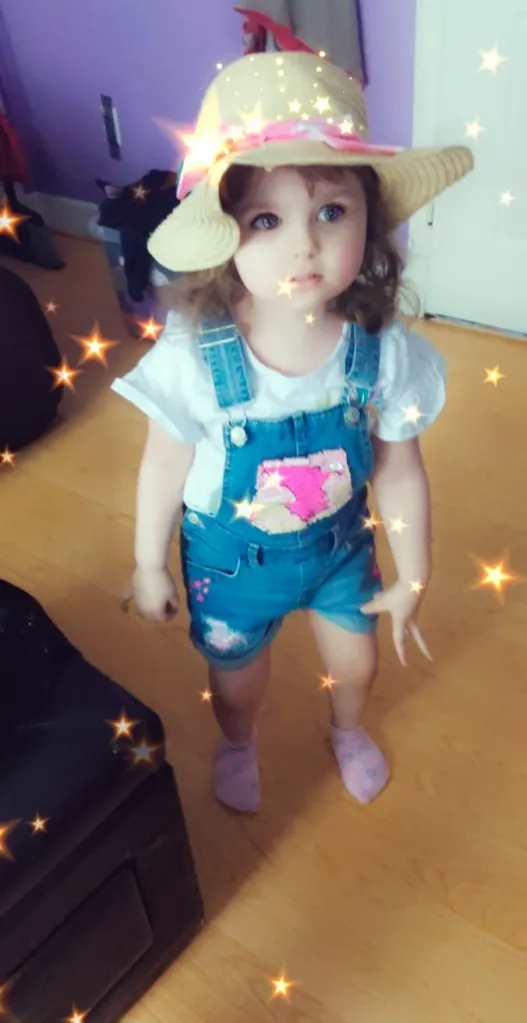 Charlotte Buskey, 5, in denim overall shorts and a white t shirt and floppy hat