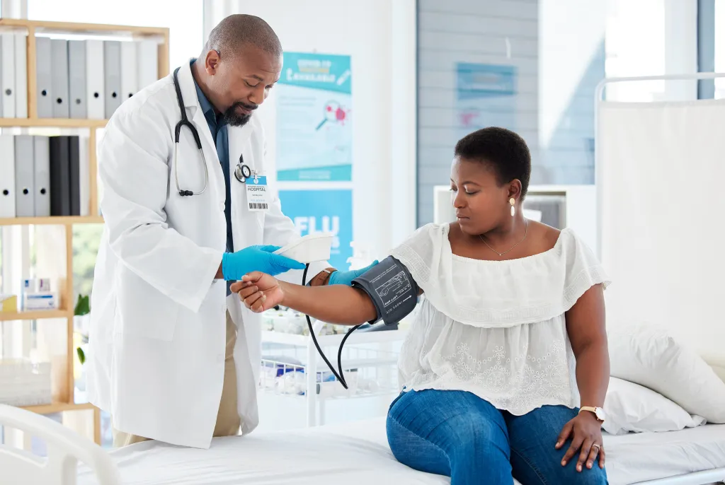 Doctor measuring a female patient's blood pressure.