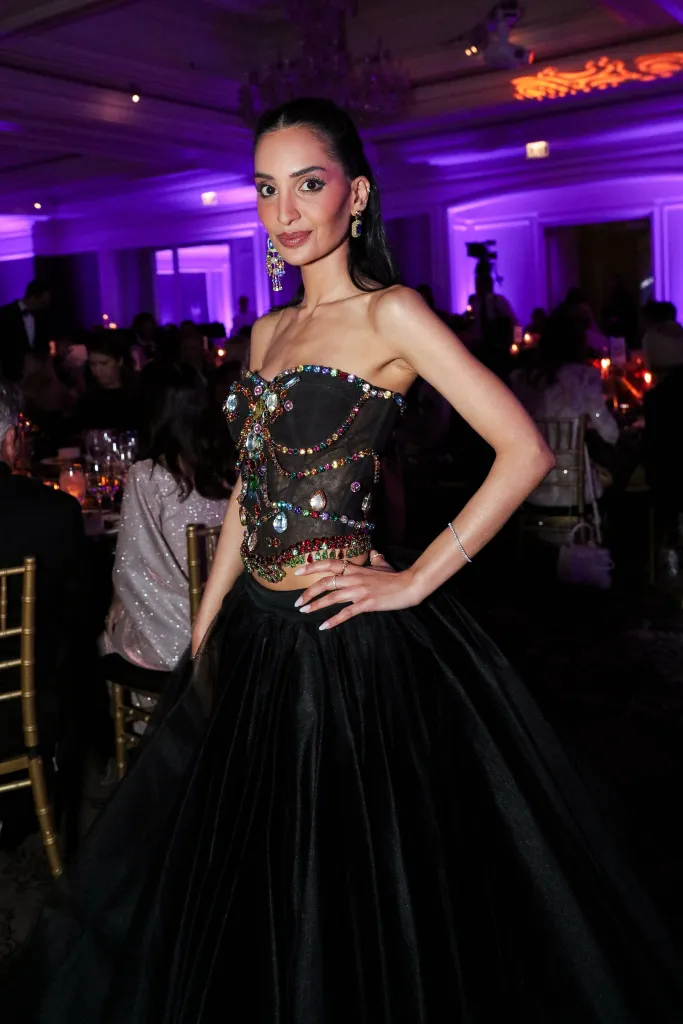 Priya Jain wearing a black jeweled top and black floor-length skirt.