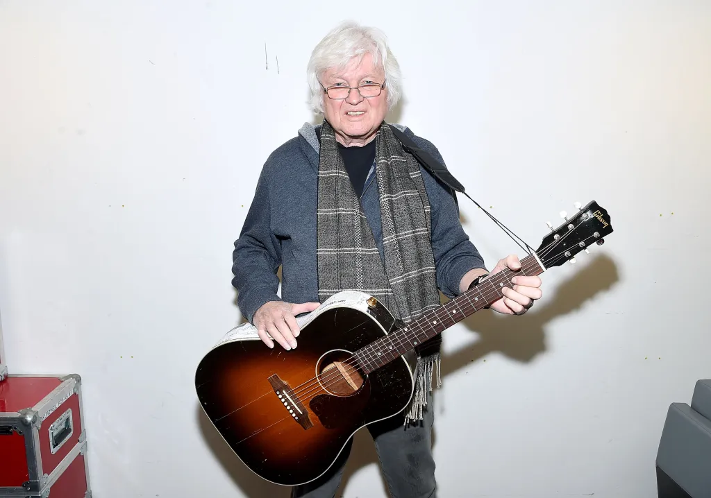 Chip Taylor holding his acoustic guitar.