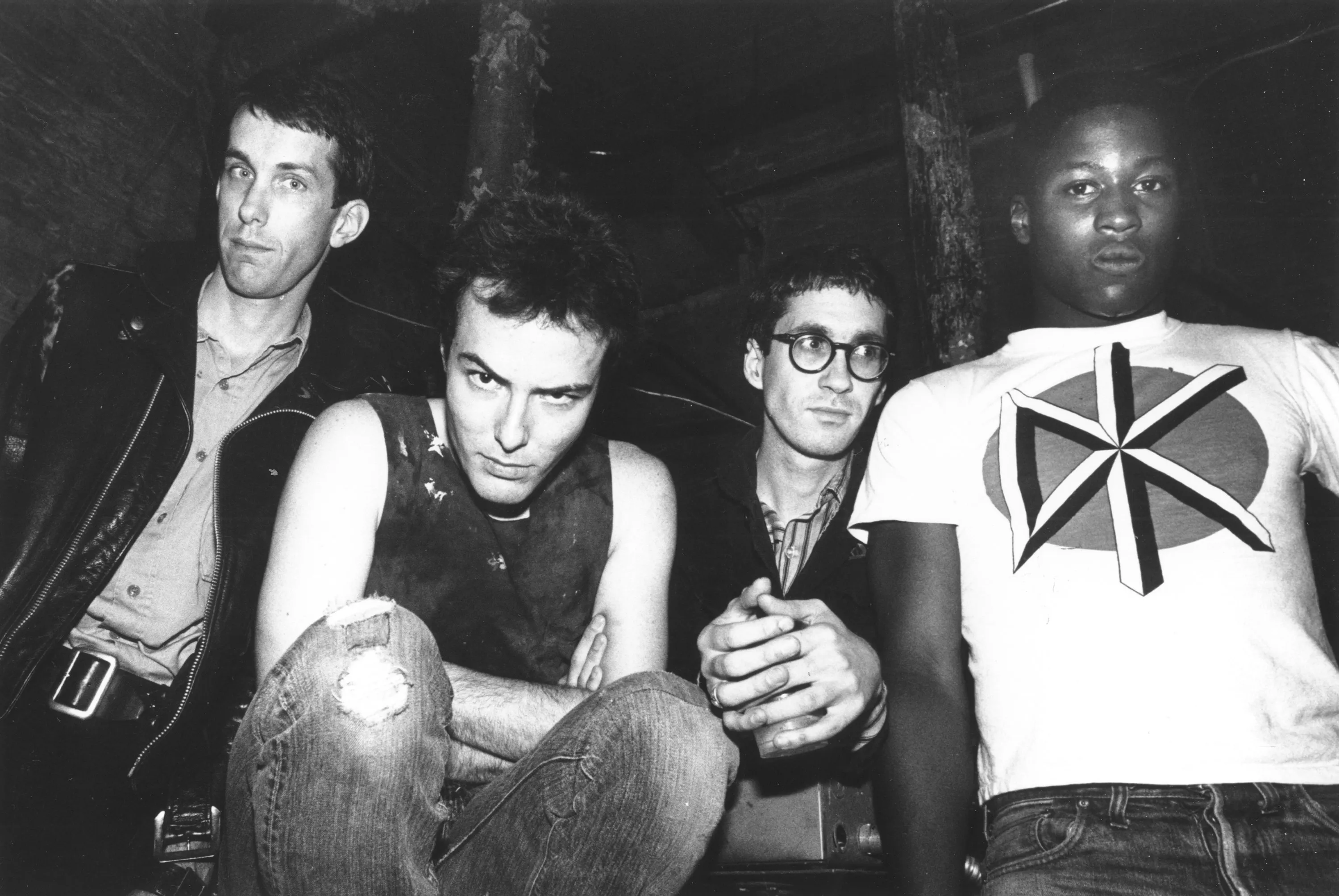 A black and white photo of the Dead Kennedys, four young men, standing close together and looking into the camera.