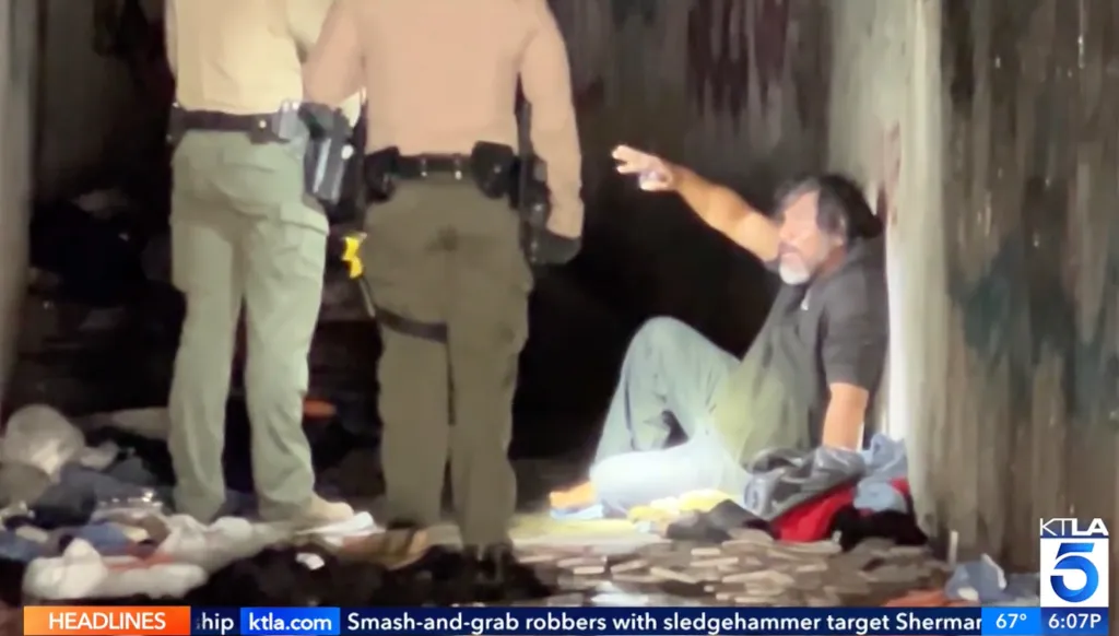 City officials clearing a homeless encampment inside a storm drain.