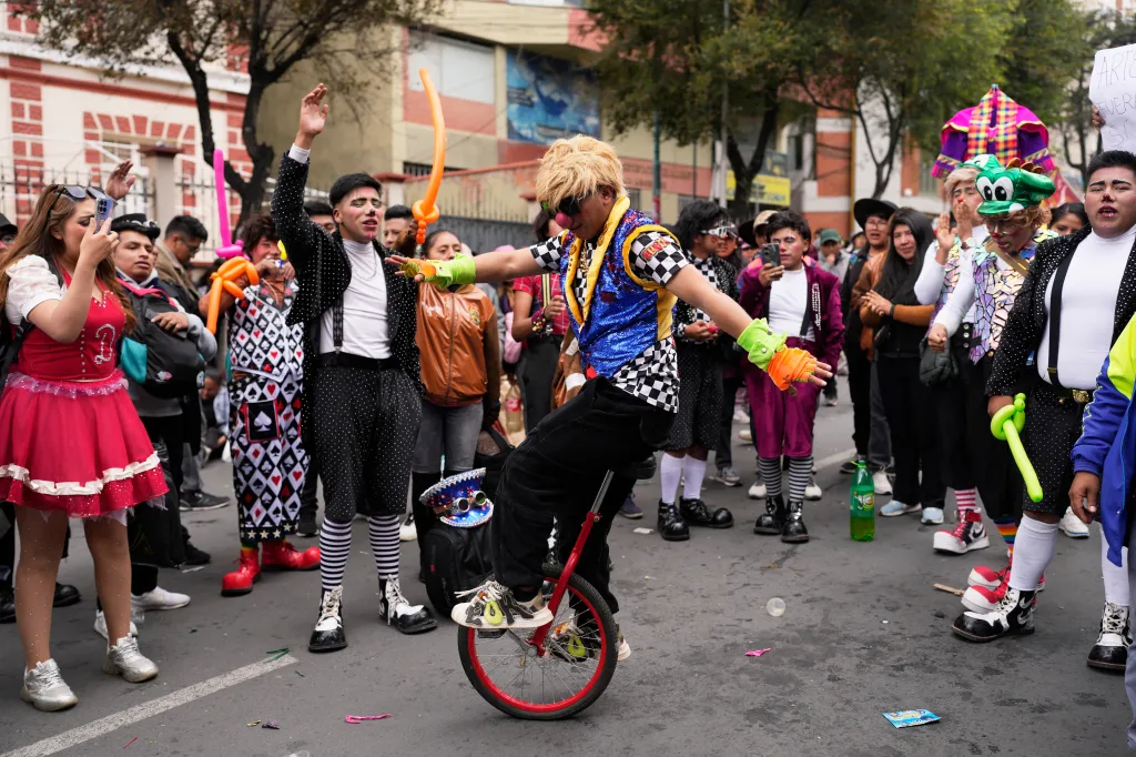A clown rides a unicycle during a protest against the government's ban on holiday parties at schools.