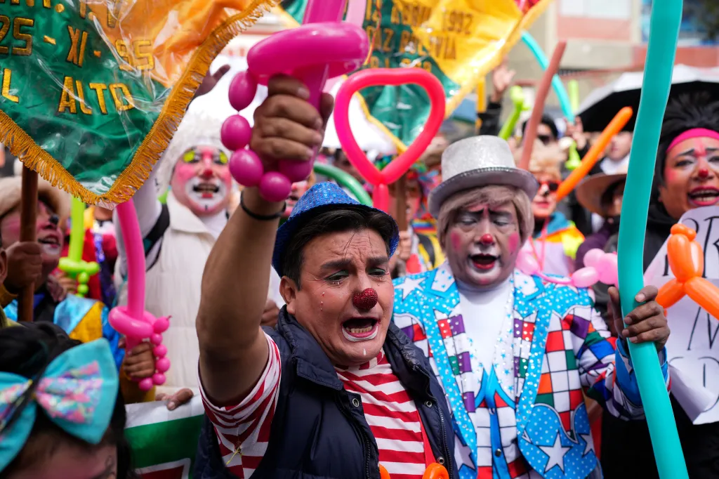 Clowns protest in La Paz, Bolivia, holding signs and balloon animals.