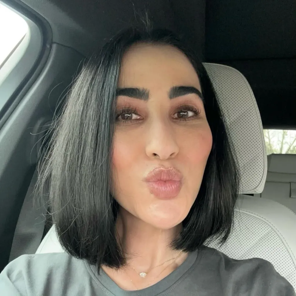 A selfie of a woman in a green shirt.