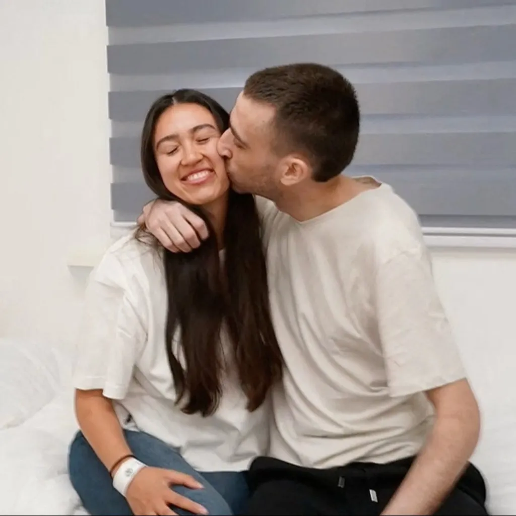 Argamani smiles as Or kisses her on the cheek.