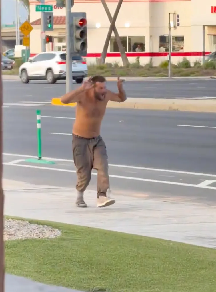 Shirtless man shouting on a street corner in Fresno.