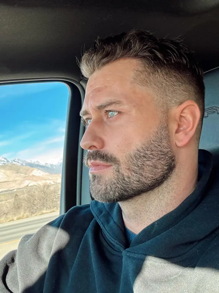 Dakota Mortensen in a car looking out the window at a mountain landscape.